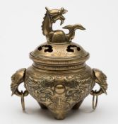 A Chinese polished bronze tripod censer and cover: the domed and pierced cover with dragon head