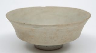 A Chinese pottery bowl: of footed shallow circular form under pale celadon glazes, 12 cm diameter,