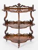 A Victorian walnut serpentine fronted three tier whatnot:,