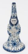 A Dutch delft figural table bell: in the form of a standing wizard-like figure with tall hat,