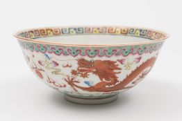 A Chinese famille rose dragon and phoenix bowl: painted with a dragon and a phoenix persuing a