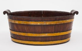A Georgian mahogany brass bound oyster pail: of oval outline and coopered construction with scroll