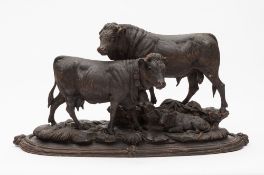 A large Swiss Black Forest carved linden wood bovine group: of a cow and calf and bull mounted on