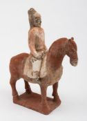 A Chinese painted pottery horse and rider: cold painted in red and grey pigments,