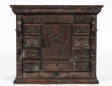 An early 18th century Italian carved walnut cabinet: decorated with paterae, masks,