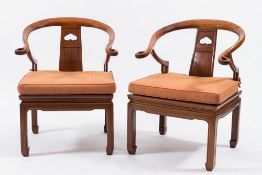 A pair of Chinese hardwood armchairs: of tub-shaped outline the backs with shaped top rails and