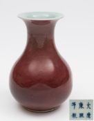 A Chinese porcelain peach bloom vase: of squat baluster form the pale flambé glaze darkening