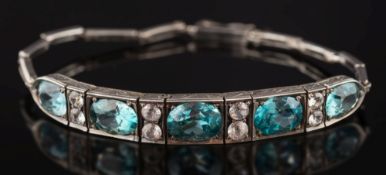 A silver and blue and white zircon thirteen-stone bracelet: with oval blue zircons between pairs of