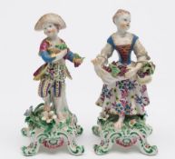 A pair of Bow figures of grape sellers: the youth holding a bunch of grapes in each hand,