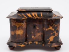 A 19th century tortoiseshell tea caddy: of serpentine outline, with shallow domed hinged lid,