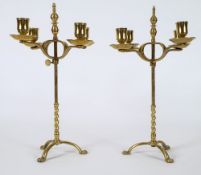 A matched pair of 19th century brass four-branch candelabra: with plain urn-shaped nozzles with