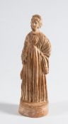 A Roman hollow cast terracotta figure of a young woman: wearing long flowing robes, on oval base,