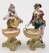 A pair of Minton figures of flower and fruit sellers: the gallant and lady holding a bunch of