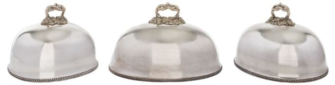 A graduated set of silver plated meat dish covers: of domed outline with grape and vine leaf