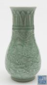 A Chinese celadon glazed vase: of tapering form the body carved with a pair of dragons competing