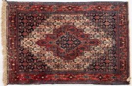 A Hamadan rug:, the cream field with a central rose stepped pole medallion,