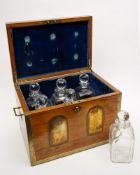 A 19th century oak and brass bound six decanter campaign tantalus: the hinged lid enclosing a