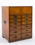 A collector's late 19th century oak cabinet: with a hinged fall and containing twelve drawers with