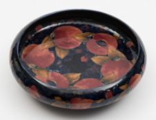 A Moorcroft pottery bowl: of circular form, tube lined in the Pomegranate pattern in red,