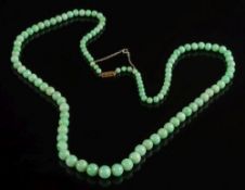 A graduated green jade bead single-string necklace: with spherical mottled green beads graduated