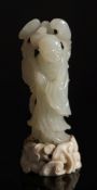 A Chinese carved jade carving of a man holding lingzhi sprays: with smiling expression and wearing