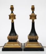 A pair of Regency-style bronzed metal table lamps: with reeded flared stems on square acanthus