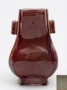 A Chinese flambe-glazed porcelain vase, Fanghu: of pear-shaped rectangular form with lug handles,