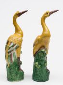 An opposing pair of Chinese porcelain figures of cranes: each with arched necks and one leg raised