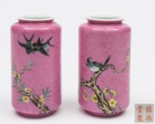 A pair of Chinese pink ground vases: of cylindrical form with short everted rims,