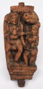 An 18th century Indian carved hardwood erotic figure group panel: the figures standing on a plinth