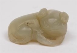 A Chinese carved jade figure of a reclining beast: the stone of celadon colour, 5cm. long.