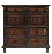 A Jacobean oak and marquetry rectangular chest: in two parts, the top with a moulded edge,