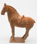 A Chinese terracotta figure of a horse: standing four-square, on plain rectangular base,