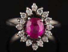 A synthetic ruby and diamond oval cluster ring: the central oval ruby 6mm long x 5mm wide,
