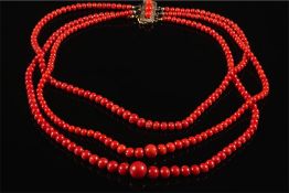 A graduated coral bead three strand necklace: the beads graduated from 3mm diameter to 11mm