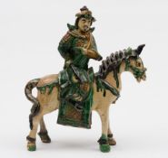 A Chinese 'sancai' glazed equestrian figure of a warrior: wearing ornate tunic and decorated in