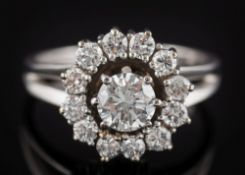 A diamond mounted circular cluster ring: with central round brilliant-cut diamond approximately 0.