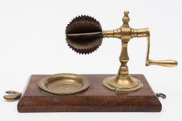 A 19th century brass and steel coconut grater: with circular grater on turned column with winding
