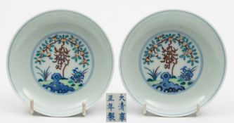 A pair of Chinese doucai saucer dishes: each enamelled with a peach branch,