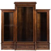 A late 19th century walnut breakfront library bookcase in the Aesthetic taste: with turretted top