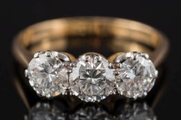An 18ct gold and diamond three-stone ring: with circular brilliant-cut diamonds approximately 0.