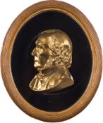 A 19th century gilt metal low relief portrait plaque of a gentleman: with shoulder length hair and