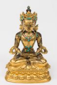 A Burmese gilt-bronze and turquoise mounted study of Buddha: seated cross legged,