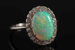 An opal and diamond oval cluster ring: the oval opal approximately 12.7mm long x 9.