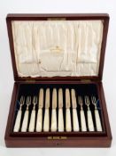 A George V set of twelve mother of pearl and silver fruit knives and forks, maker Mappin & Webb,