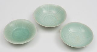 Three Chinese porcelain pale celadon bowls: of thinly potted form with petal shaped rims the centre