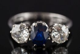 A sapphire and diamond three-stone ring: with central oval sapphire approximately 0.