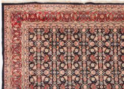 An Indo Persian carpet:, the indigo field with an all over geometric design of palmettes,