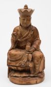 A Chinese carved wood figure of Guanyin: wearing elaborate robes and headdress and seated on double