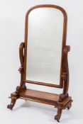 A Victorian mahogany swing frame cheval mirror:, the plate with an arched moulded surround,